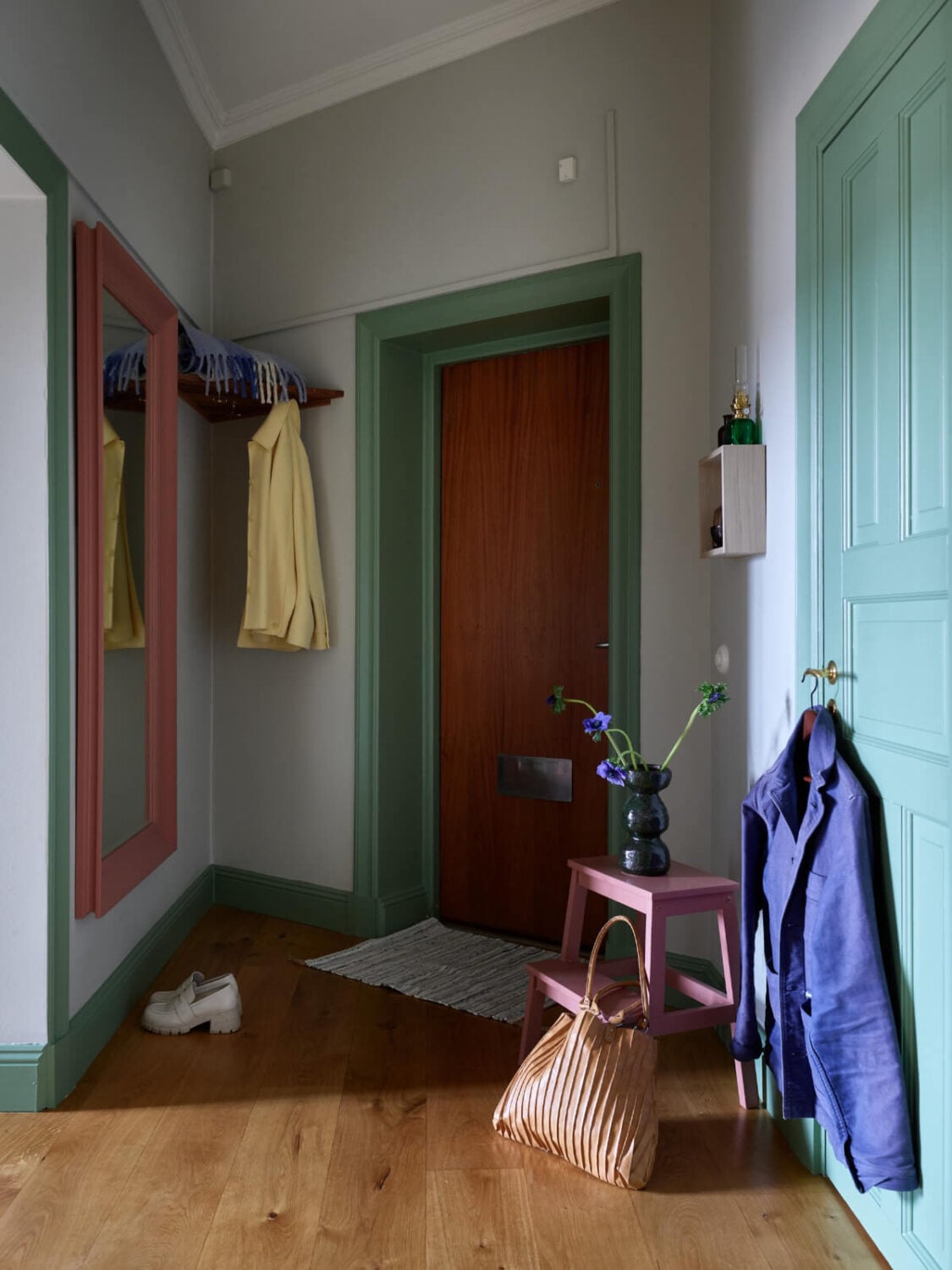 Lovely Color Combinations in a Charming One-Bedroom Apartment 23 hall green woodwork large pink mirror Lovely Color Combinations in a Charming One-Bedroom Apartment