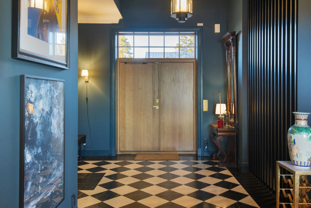 English Manor Style Interiors in a New Swedish Home with Lake Views 17 hall large wooden doors checkerboard floor