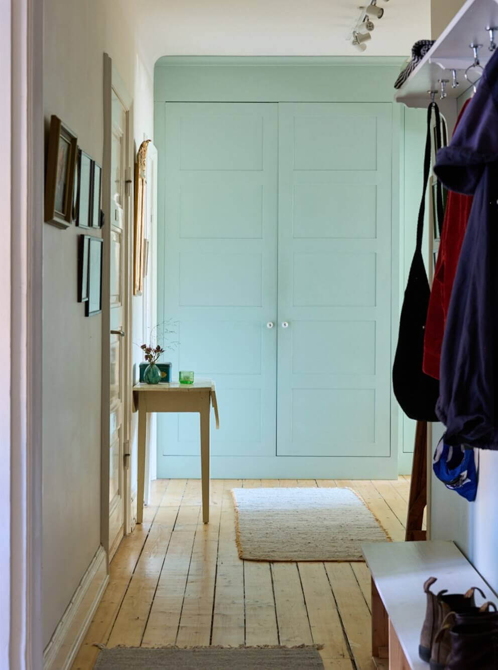 A Charming Apartment with Period Details in Malmö 17 hall with mint green built-in wardrobes