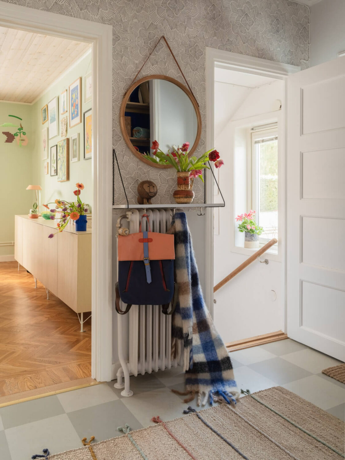 Colorful Decor in a Charming Family Duplex Apartment in Stockholm 20 hall with shelf above radiator and round mirror