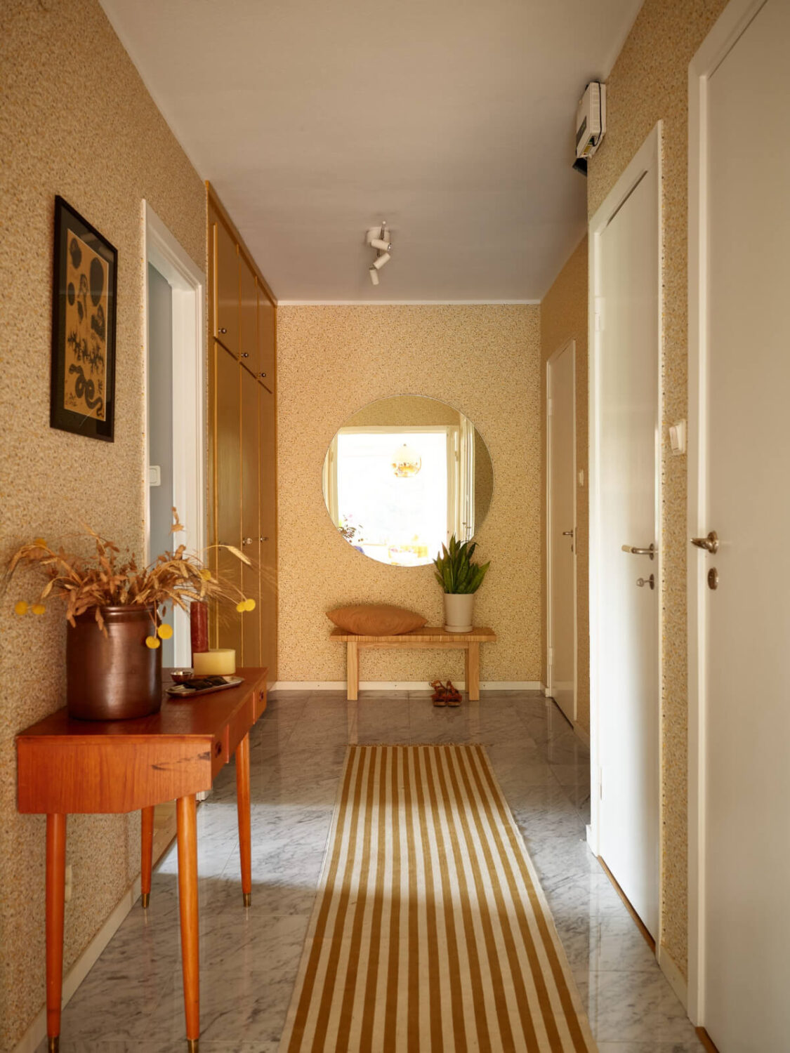 A Lovely Color Palette in a Midcentury Apartment in Sweden 24 hall with yellow wallpaper marble floor tiles