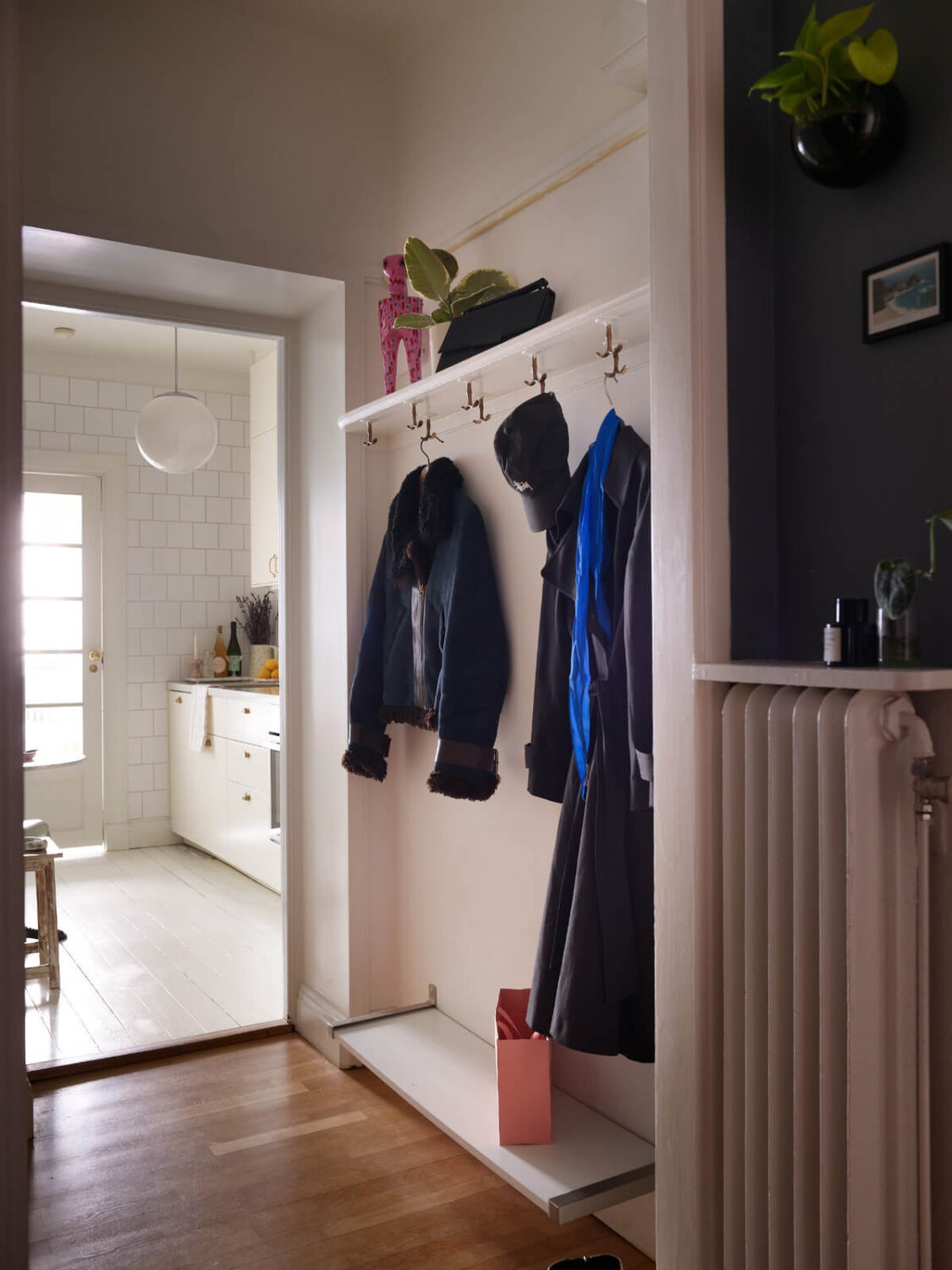 A Charming Small Apartment with a Fresh White Kitchen 20 hallway hat shelf