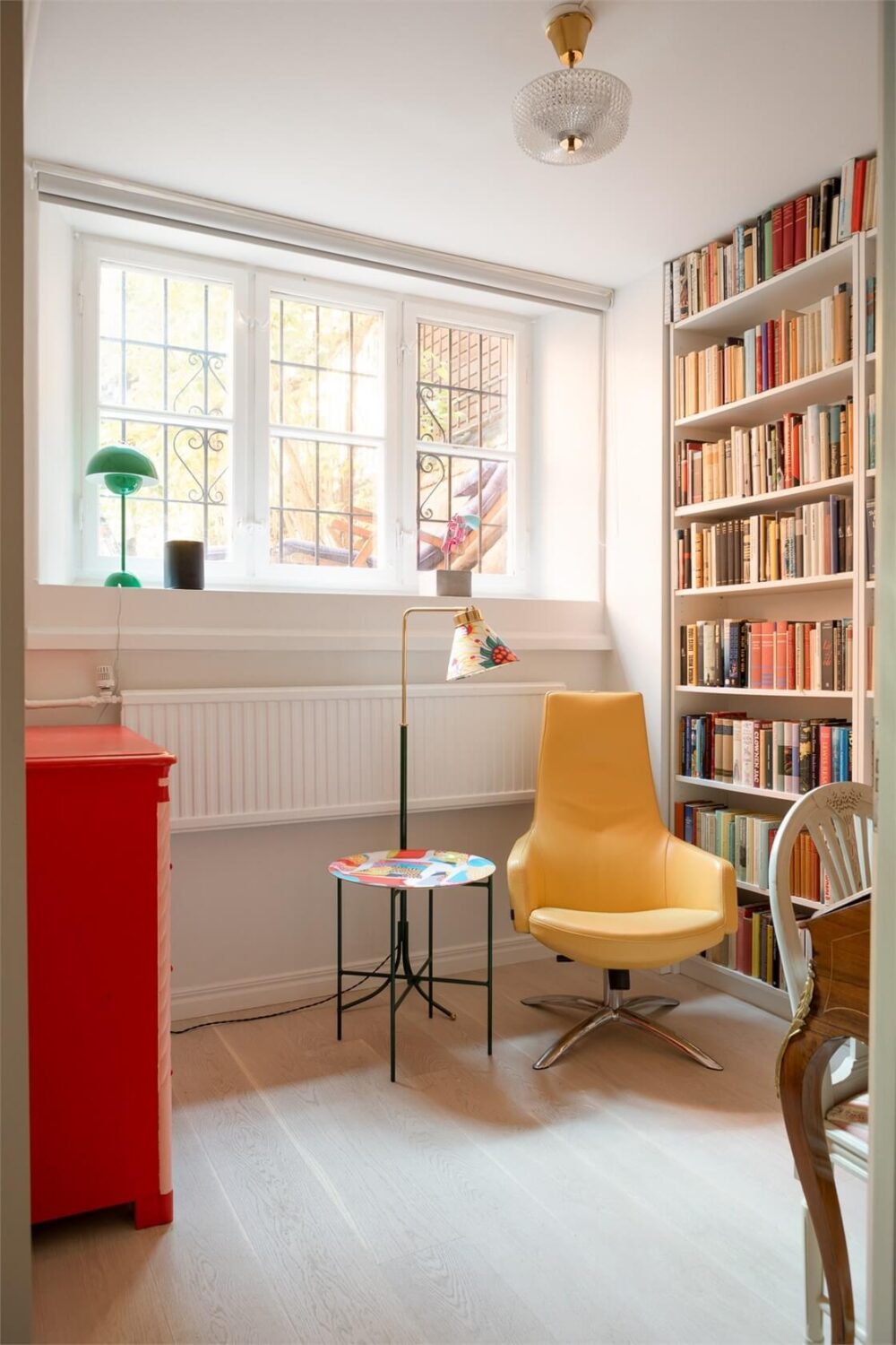 A Colorful Basement Duplex Apartment in Stockholm 7 home office high windows bookshelves