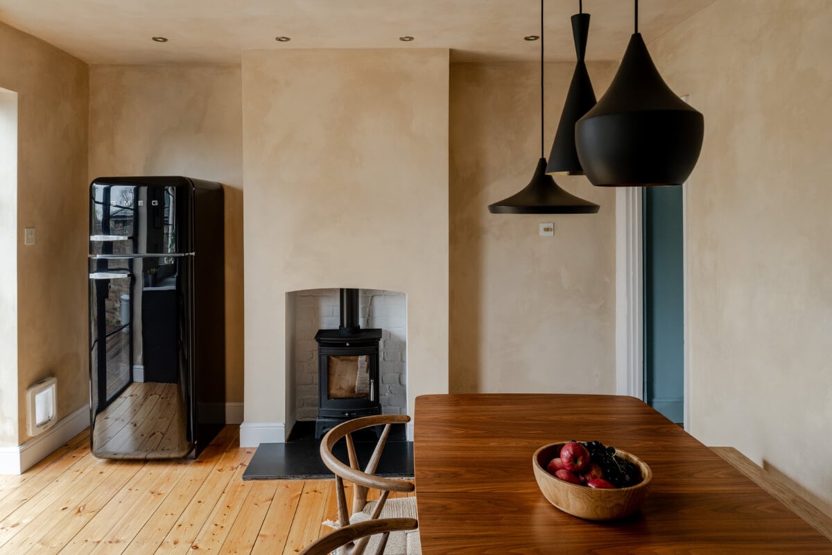 A Contrasting Color Palette in a Renovated Terrace House 7 kitchen and dining room plaster walls wood burner