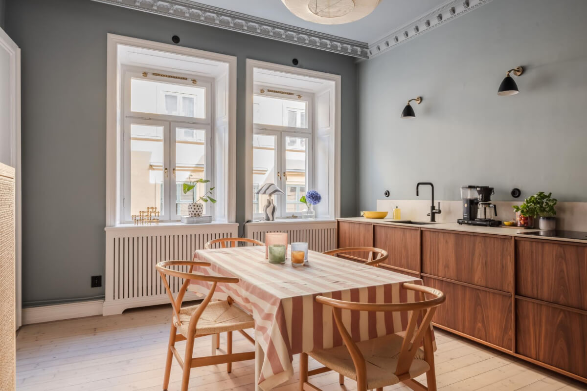 Pastel Colors and Contemporary Design in a Late 19th Century Apartment 10 kitchen blue-gray walls ceiling and walnut cabinet large table striped tablecloth