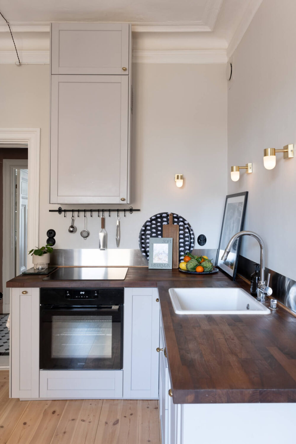 A Small Apartment Decorated in a Light Gray & White Color Palette 9 kitchen brass knobs wooden countertop