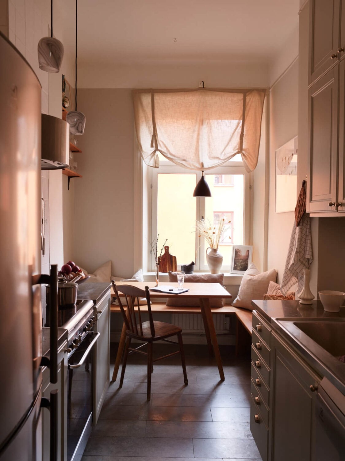 A Calm Gray Color Palette in a Charming Stockholm Apartment 11 kitchen stone floor table with bench