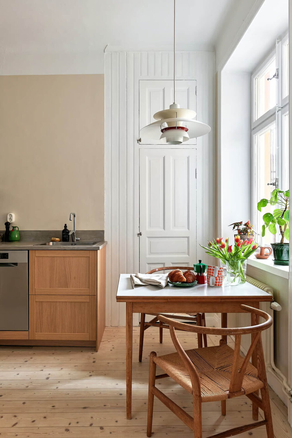 A Charming Swedish Apartment with a Spacious Balcony 10 kitchen table original pantry door