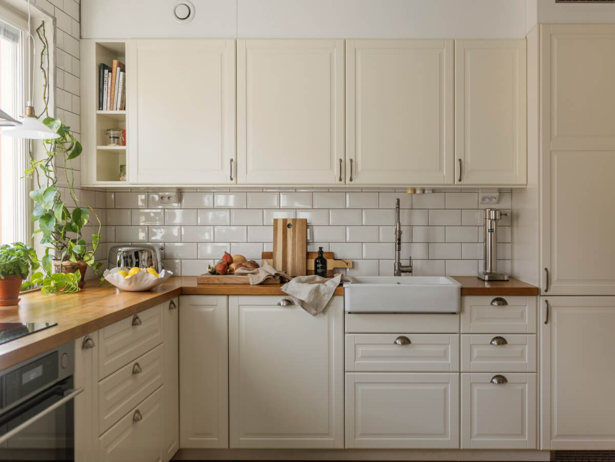 Cozy Plant-Filled Interiors in a 1940s Apartment 11 kitchen white tiles butler sink