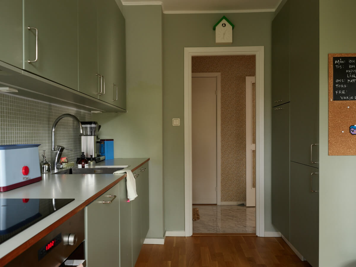 A Lovely Color Palette in a Midcentury Apartment in Sweden 18 kitchen with floor to ceiling cabints