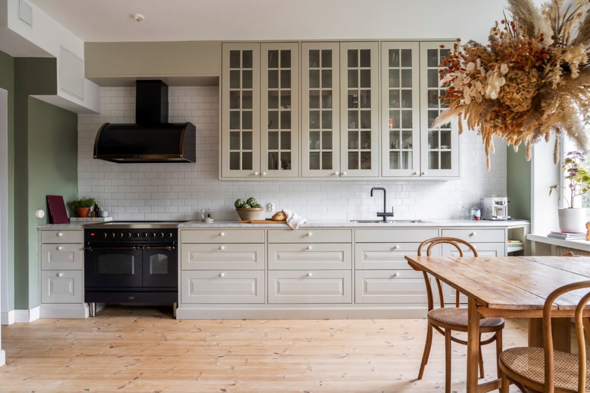 A Light Swedish Apartment with a Green Living Room 6 light green kitchen with glass fronted upper cabinets