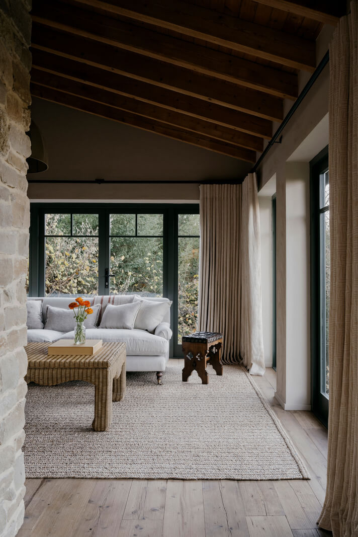 A Cozy and Contemporary Take on a Traditional Log House 2 living room large rug pitched wooden ceiling