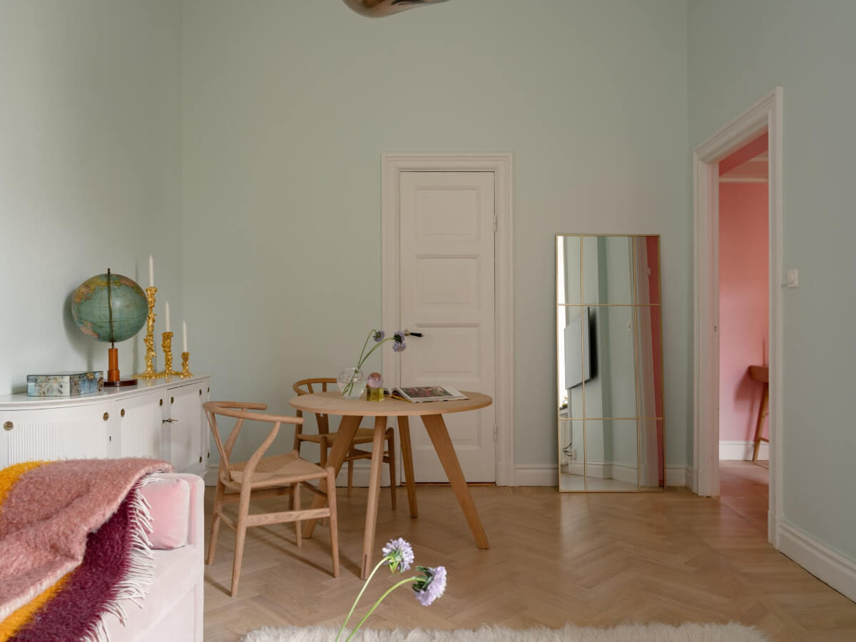 A Small Pink and Blue Apartment with High Ceilings in Stockholm 10 living room light blue walls round wooden table