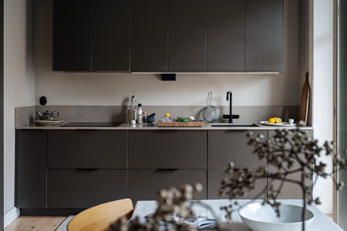 A Gothenburg Apartment with a Small Dark Green Bedroom 15 minimalistic black kitchen high upper cabinets