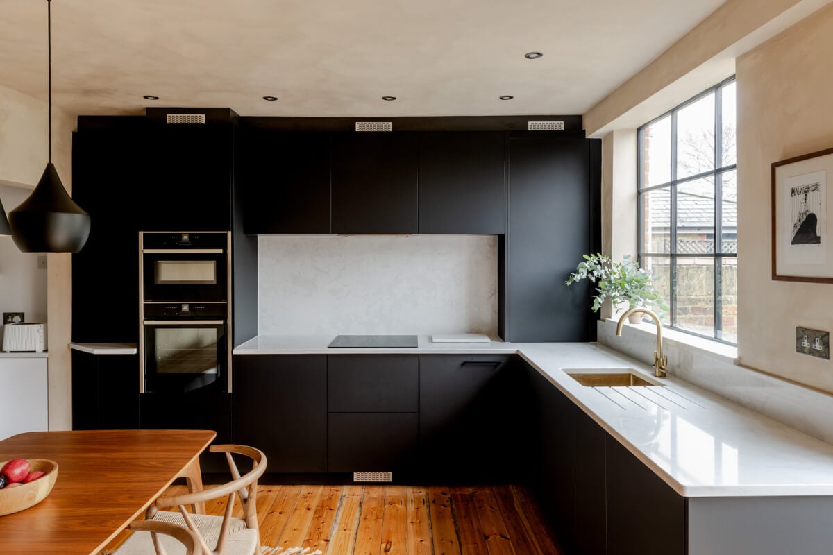 A Contrasting Color Palette in a Renovated Terrace House 4 modern black kitchen with warm wooden floorboards