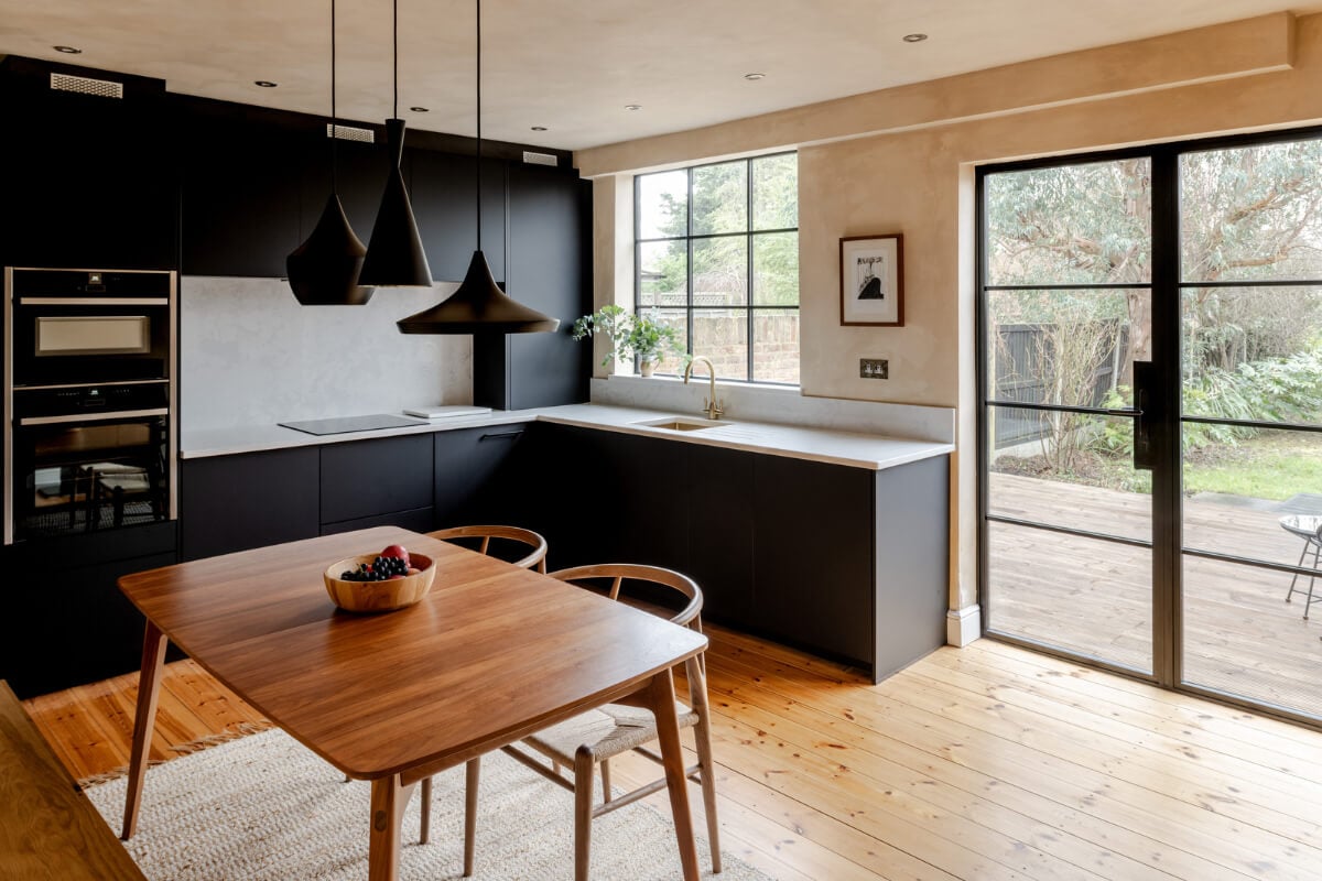 A Contrasting Color Palette in a Renovated Terrace House 3 modern black kitchen with wooden dining table