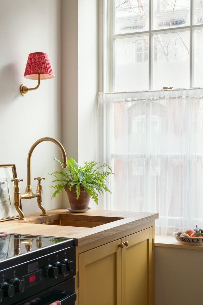 A Tiny Apartment with a Yellow Kitchen in London 2 ochre yellow kitchen cabinets brass fittings