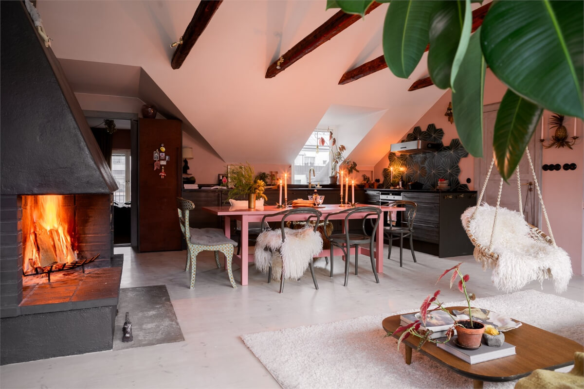 A Colorful Family Attic Apartment in Stockholm 9 open plan living space black fireplace pink dining table