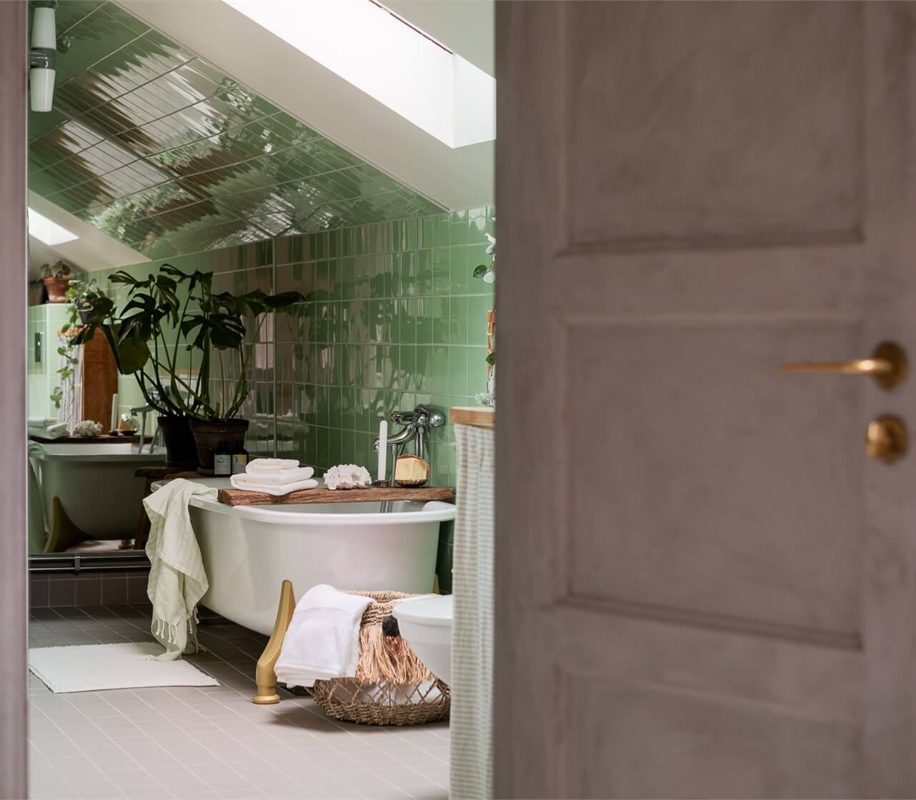 A Colorful Family Attic Apartment in Stockholm 29 peek into bathroom green tiles