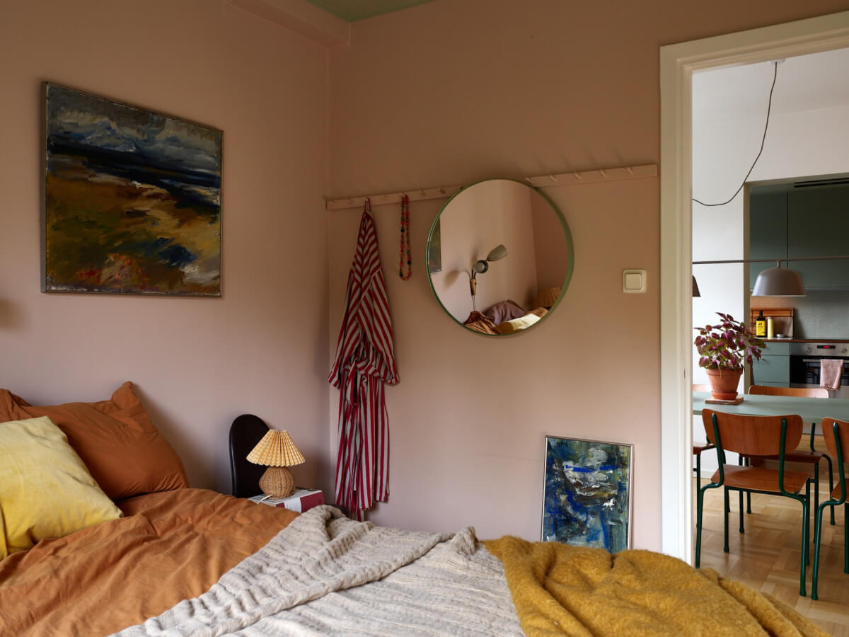 A Lovely Color Palette in a Midcentury Apartment in Sweden 22 pink bedroom round mirror