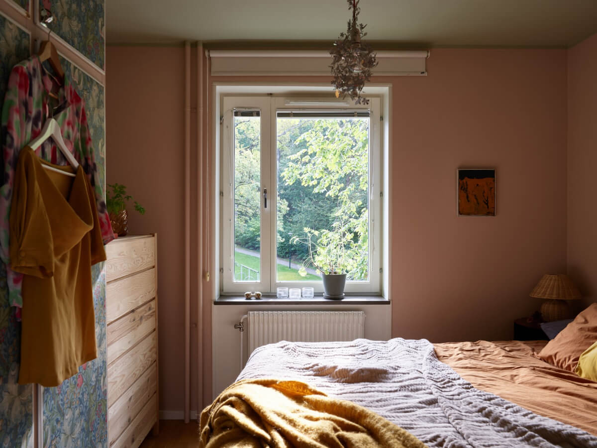 A Lovely Color Palette in a Midcentury Apartment in Sweden 20 pink bedroom wooden wardrobe green ceiling