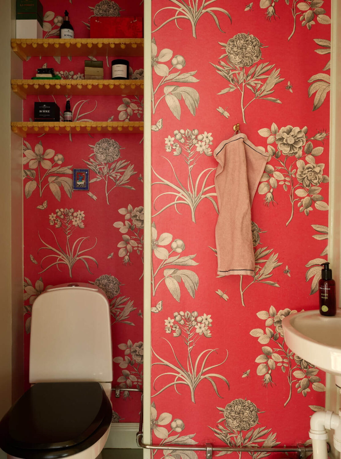 Colorful Interiors in a Wonderful Early 20th Century Swedish Villa 36 powder room orange wallpaper yellow shelves above toilet
