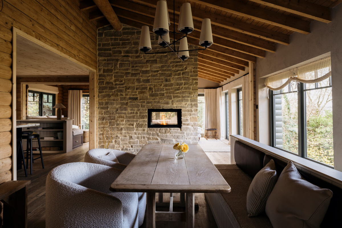 A Cozy and Contemporary Take on a Traditional Log House 8 rustic wooden table dining room large windows stone and wooden walls