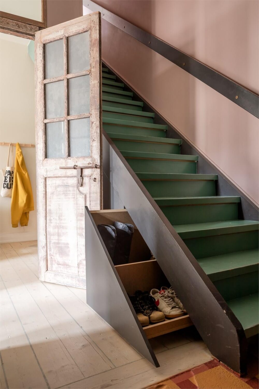 A Colorful Family Attic Apartment in Stockholm 44 shoe storage drawers under stairs
