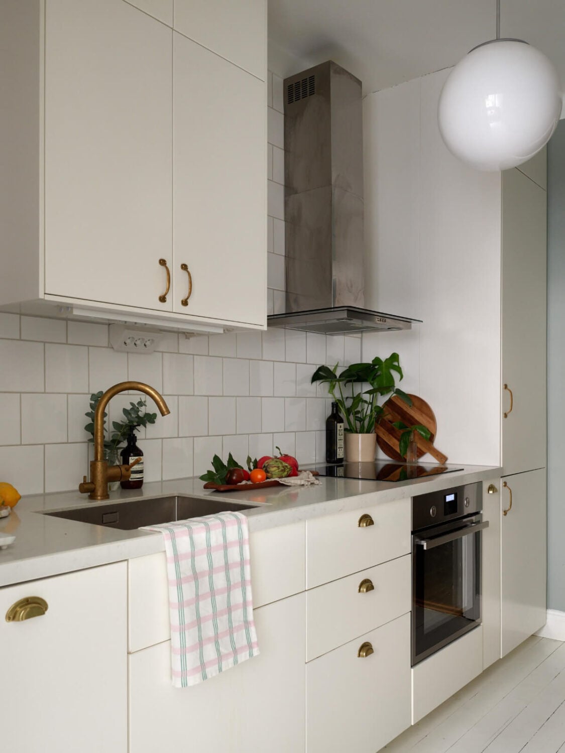 A Charming Small Apartment with a Fresh White Kitchen 12 small white kitchen brass fittings