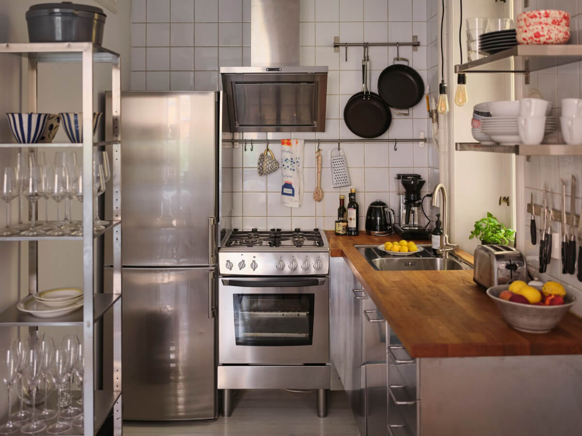 A Small Apartment with an Industrial Stainless Steel Kitchen 10 stainless steel kitchen wooden countertop