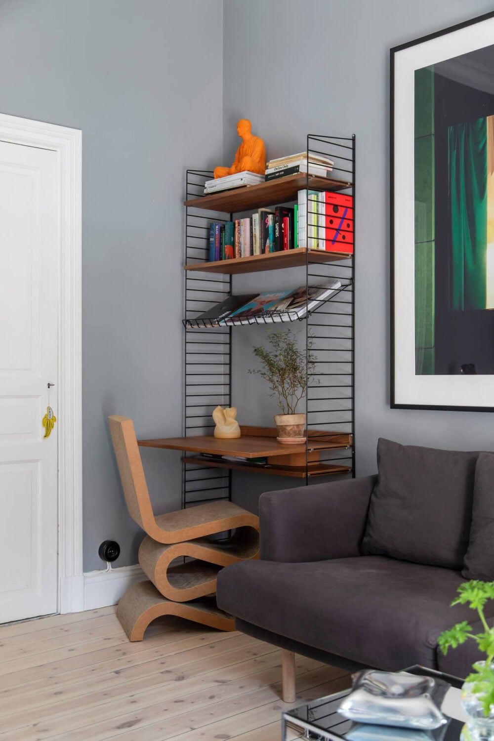 A Gray Studio Apartment with an Industrial Room Divider 7 string shelves desk sculptural chair
