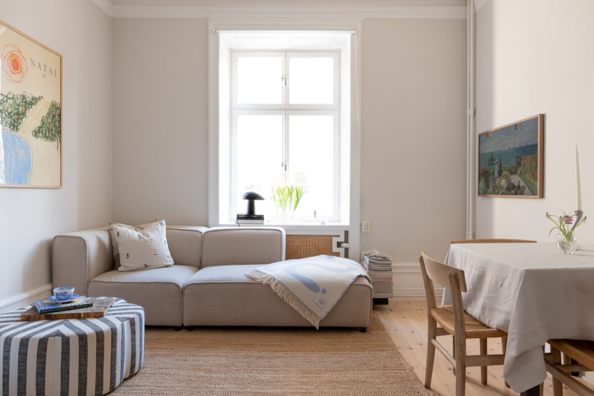 A Small Apartment Decorated in a Light Gray & White Color Palette 2 tiny light gray living room with small dining table