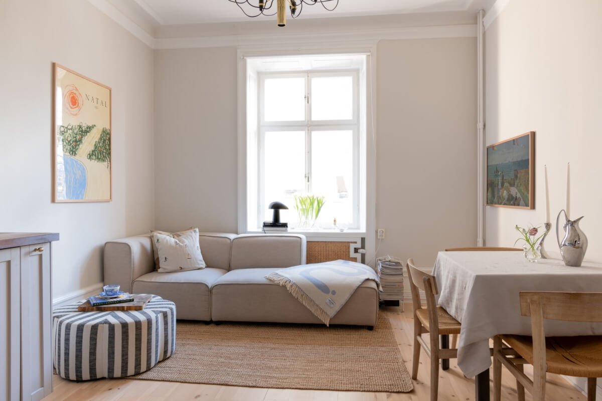 A Small Apartment Decorated in a Light Gray & White Color Palette 5 tiny living room striped coffee table ottoman