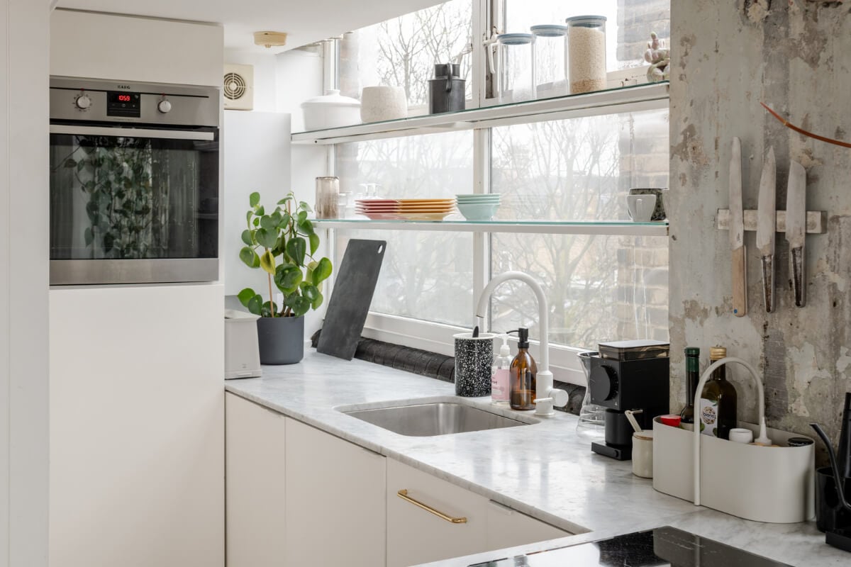 A Plant-Filled Loft Apartment in a Former Clothing Factory 9 white kitchen shelves in front of window