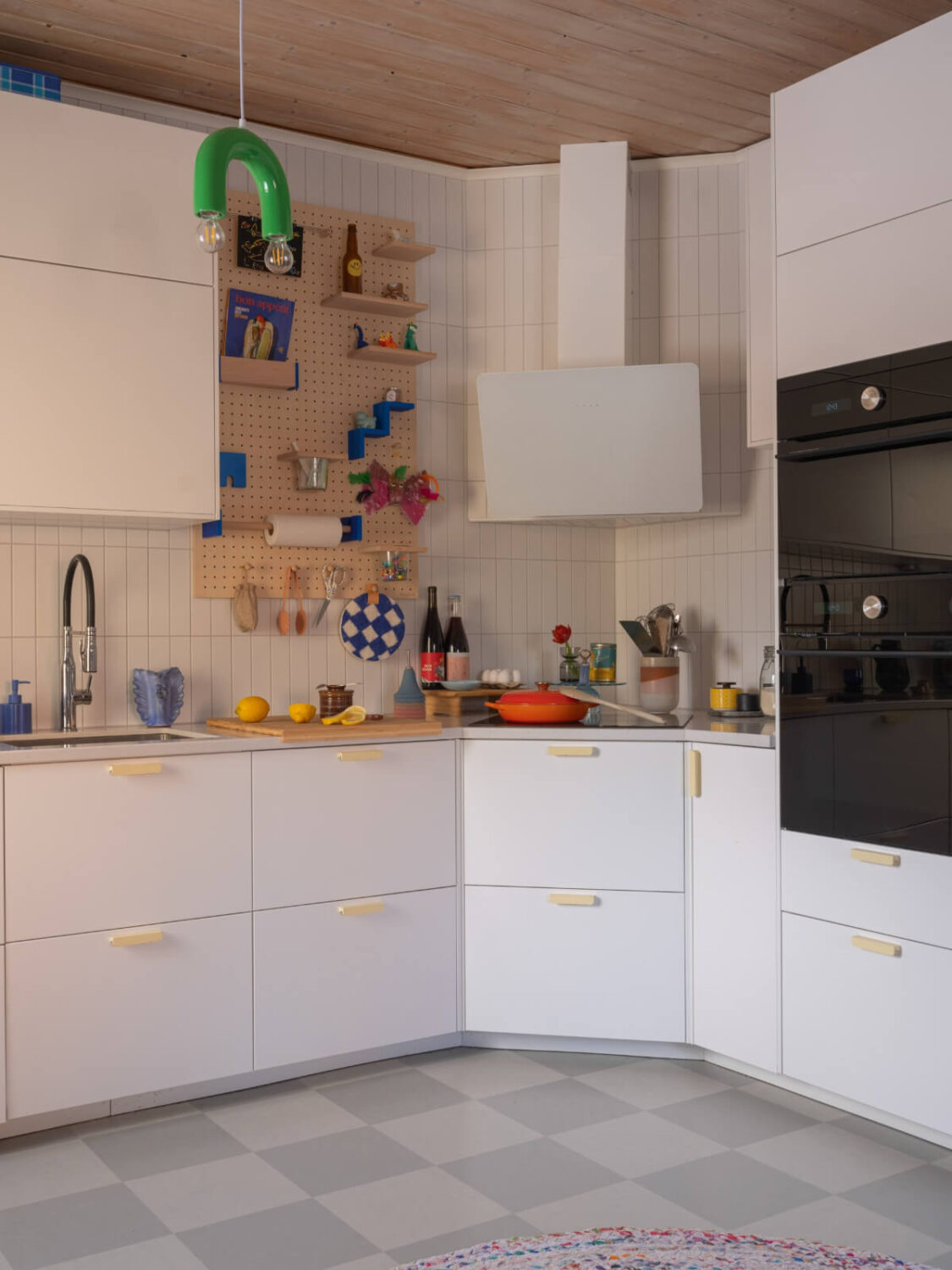 Colorful Decor in a Charming Family Duplex Apartment in Stockholm 14 white kitchen yellow handles checkerboard floor