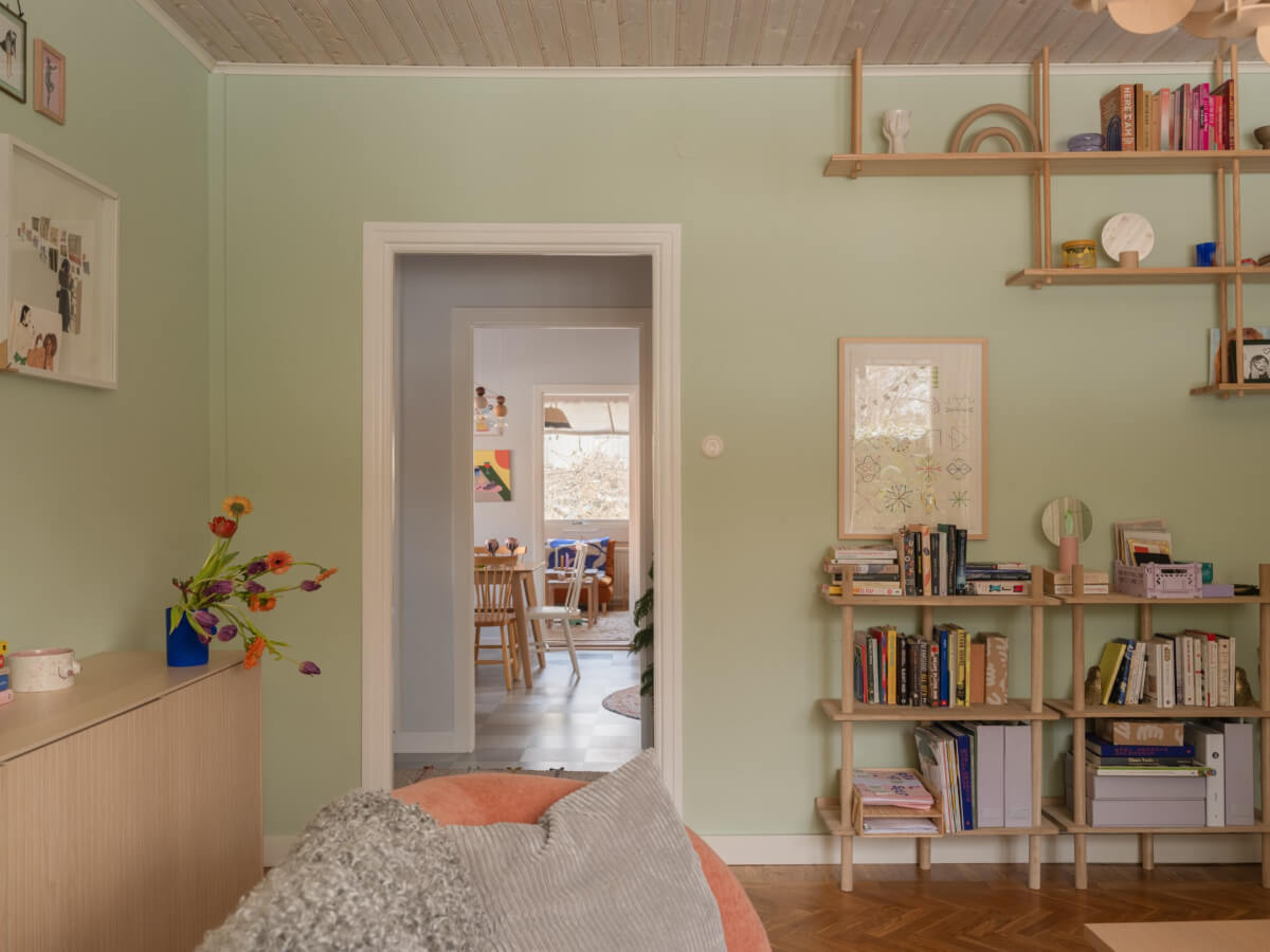Colorful Decor in a Charming Family Duplex Apartment in Stockholm 9 wooden bookshelves light green walls
