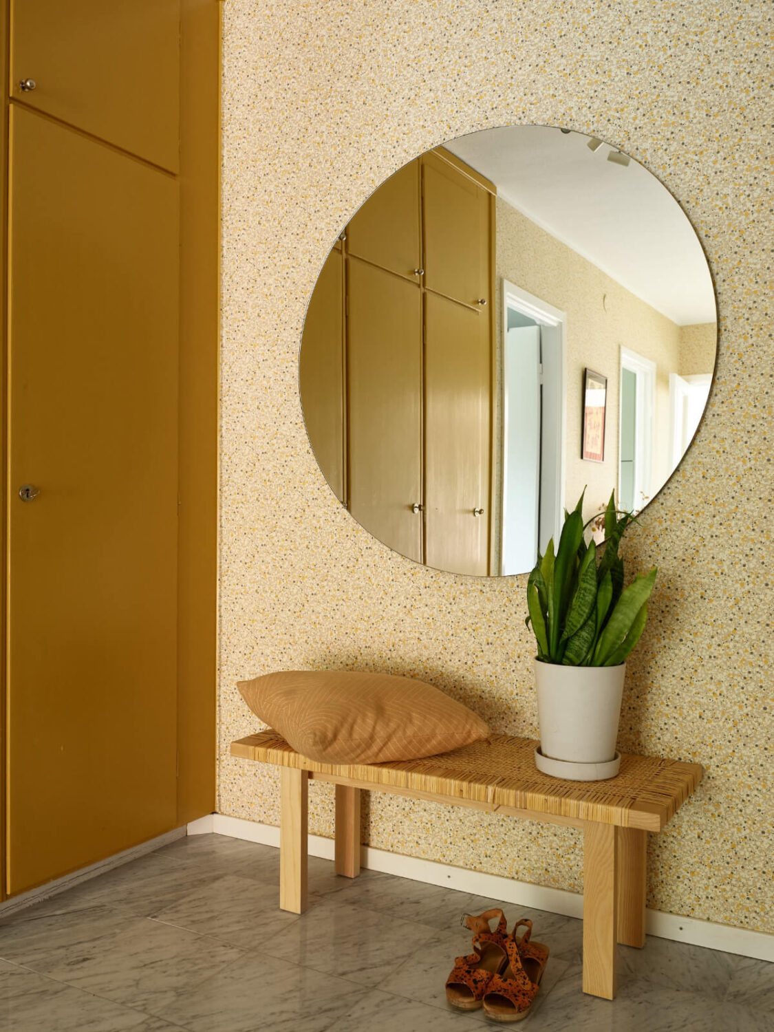 A Lovely Color Palette in a Midcentury Apartment in Sweden 29 yellow built-in wardrobes wallpaper large round mirror