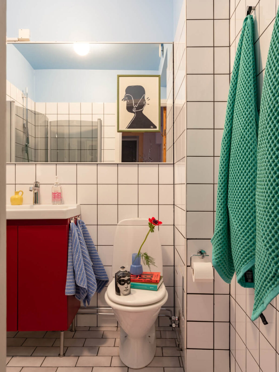 Cheerful Color Accents in a One-Bedroom Stockholm Apartment 19 bathroom blue ceiling red vanity