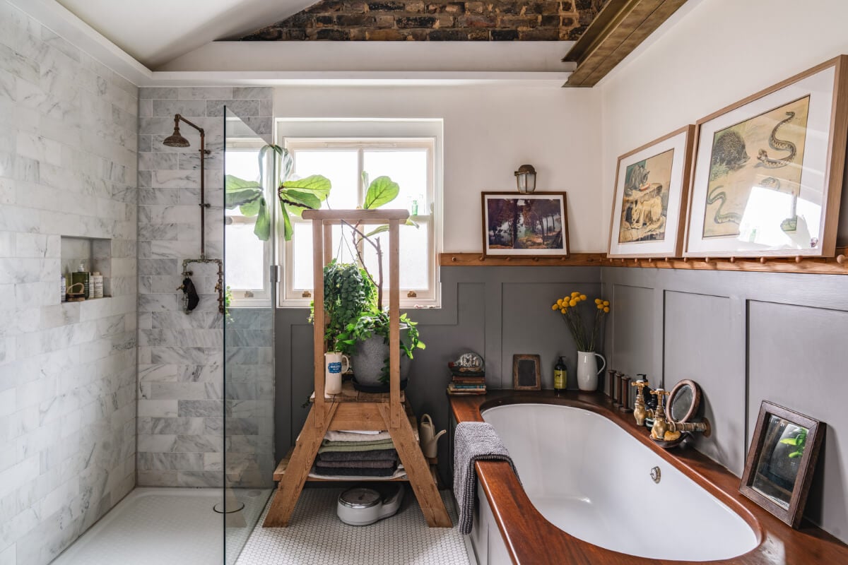 A Cozy Victorian Home Painted in Moody Blue and Gray Tones 27 bathroom pitched ceiling exposed brick marble shower tiles nordroom