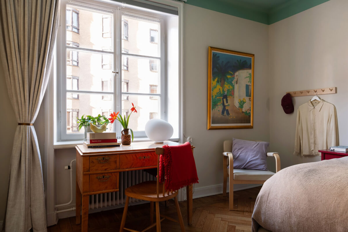 A Swedish Apartment with Period Features and Charming Color Pops 22 bedroom antique desk under window
