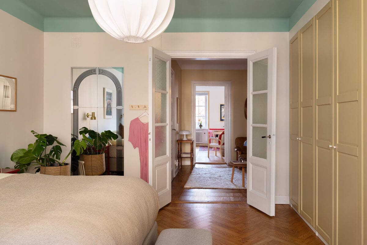 A Swedish Apartment with Period Features and Charming Color Pops 24 bedroom green painted ceiling glass doors