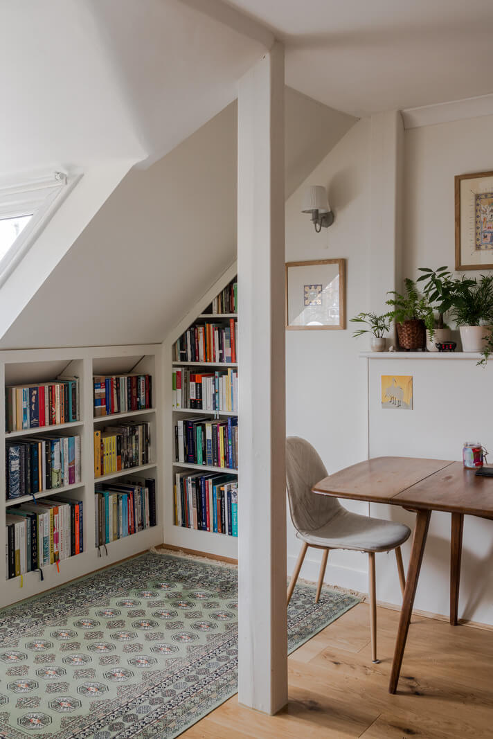 A Light-Filled London Attic Apartment with Cozy Nooks 7 bookcases under slanted ceiling
