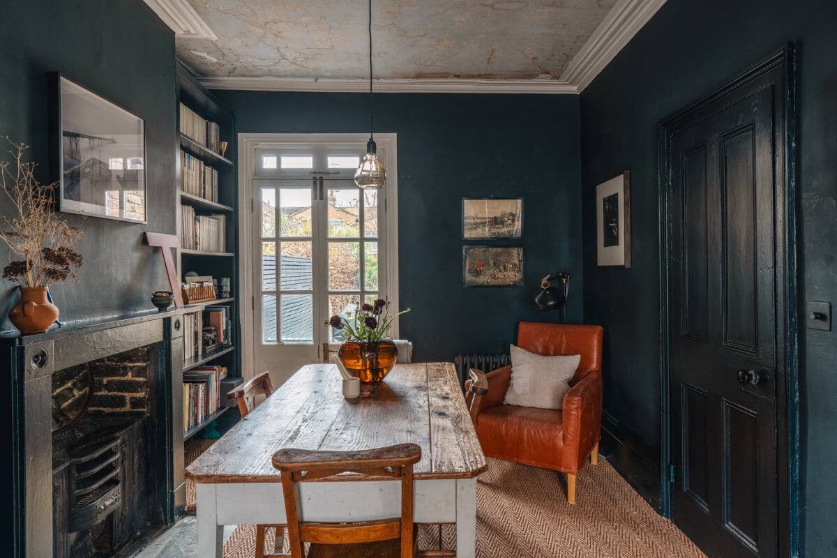 A Cozy Victorian Home Painted in Moody Blue and Gray Tones 7 dark blue dining room rustic wooden table