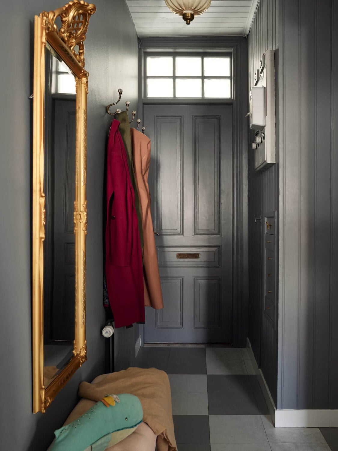 Light-Filled Rooms and a Charming Veranda in a Swedish Apartment 27 dark gray hall gilded mirror checkerboard floor