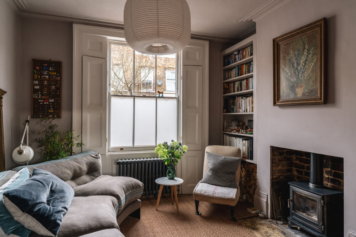 A Cozy Victorian Home Painted in Moody Blue and Gray Tones 2 gray living room log burner curved sofa