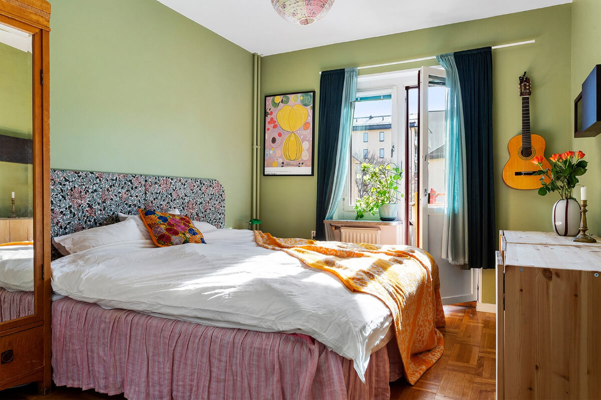 A Colorful 1940s Apartment in Stockholm 11 green bedroom antique wardrobe colorful textiles