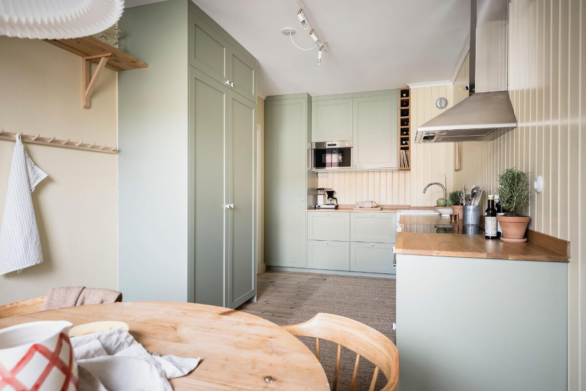 Timeless Charm and Contemporary Design in a 1930s Duplex Apartment 10 green cabinets yellow walls scandi kitchen