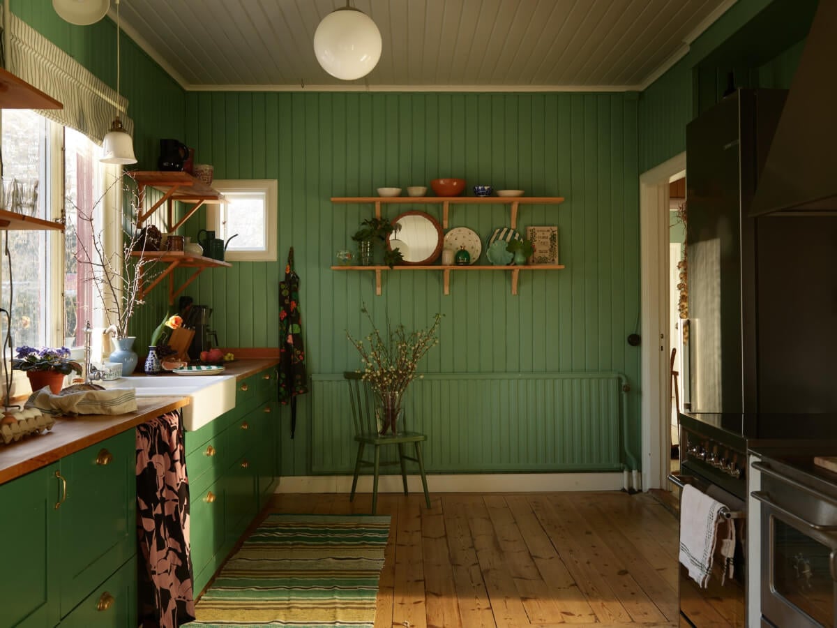 A Grand Family Home in a Former Swedish Doctor's Villa 14 green kitchen with shelves and tongue and groove paneling