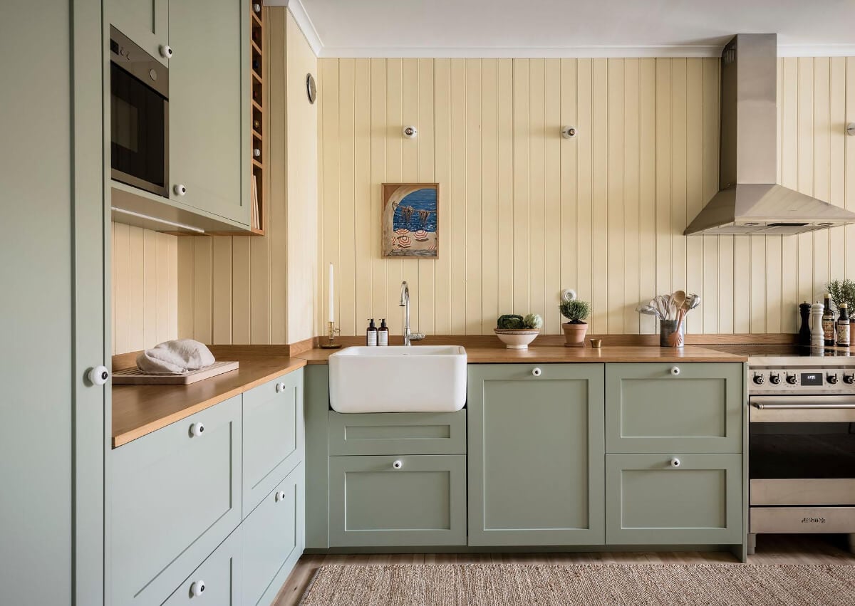 Timeless Charm and Contemporary Design in a 1930s Duplex Apartment 2 kitchen green cabinets yellow tongue and groove paneling