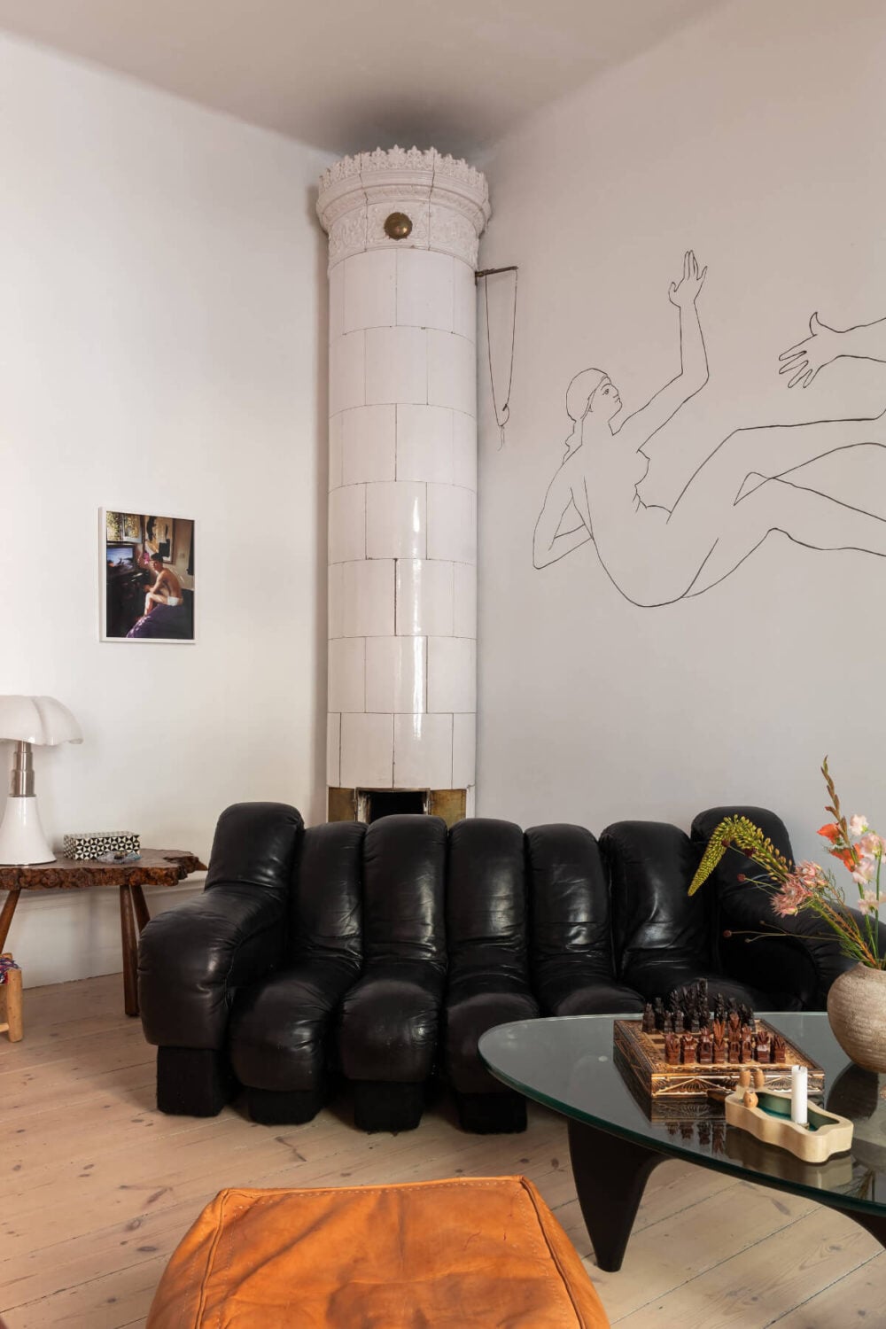 Arches and a Wall Mural in a Swedish Apartment 3 living room black sofa fireplace